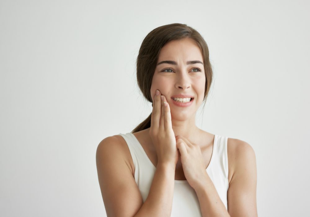 What causes a tooth to be sensitive or painful when touched on one side?